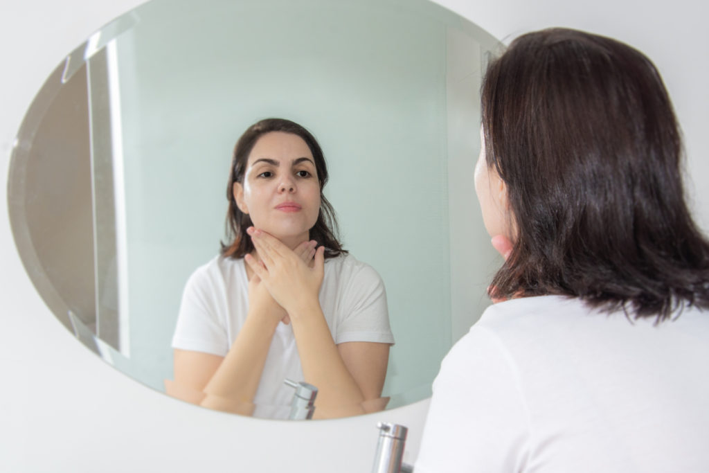 A woman examines her skin type